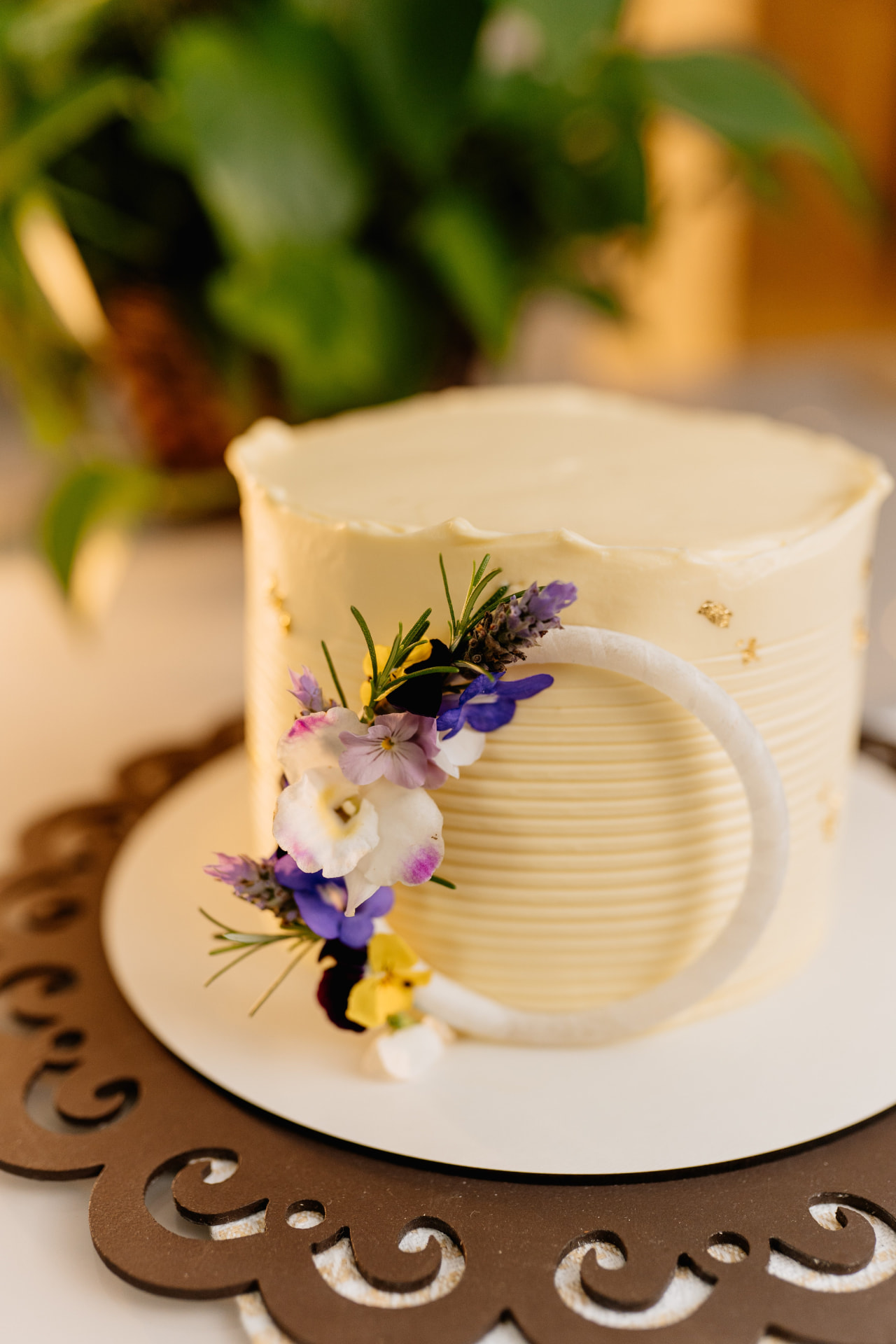 Bolo branco decorado com flores comestíveis e folhas